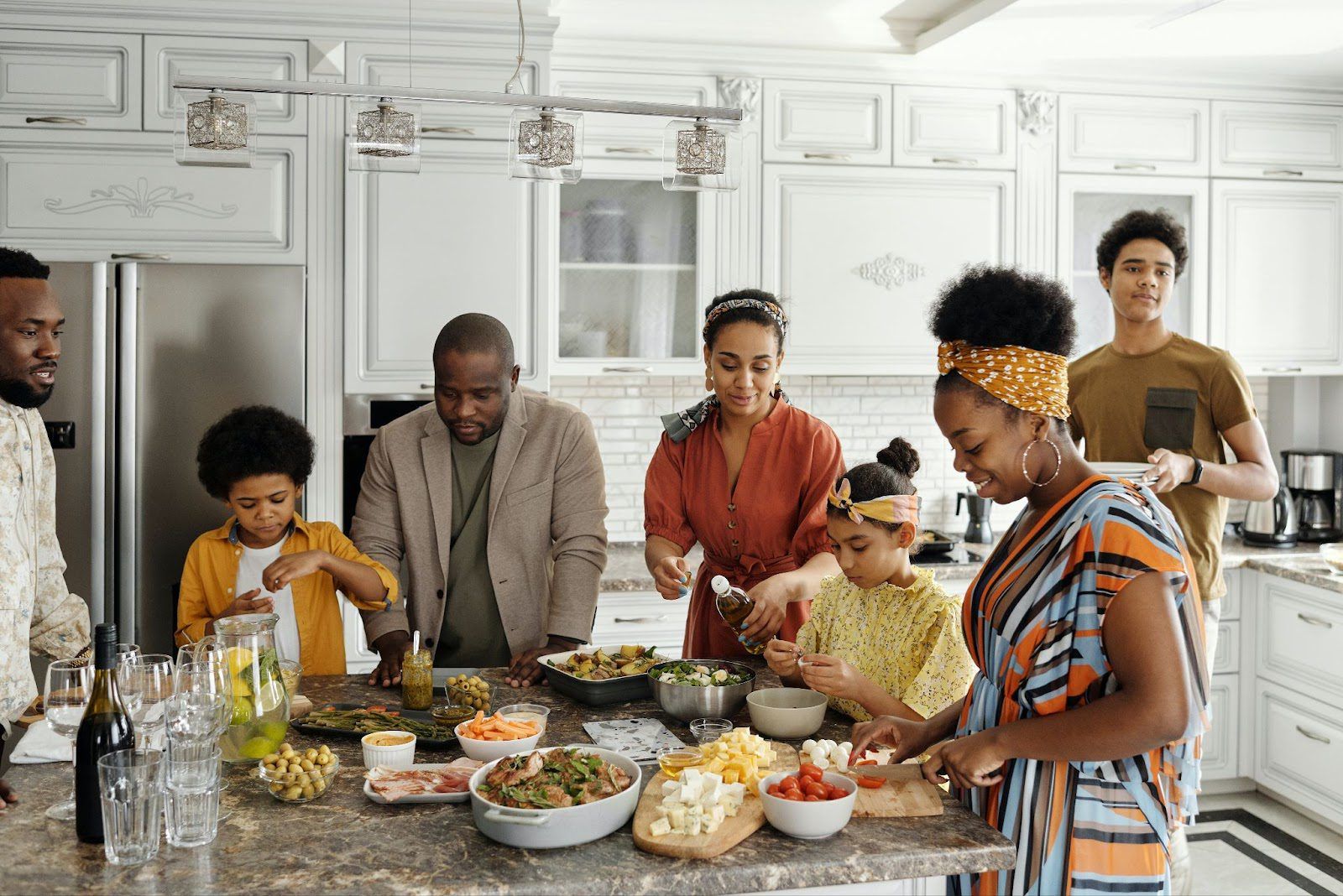 Blended family gathered around the kitchen island making dinner