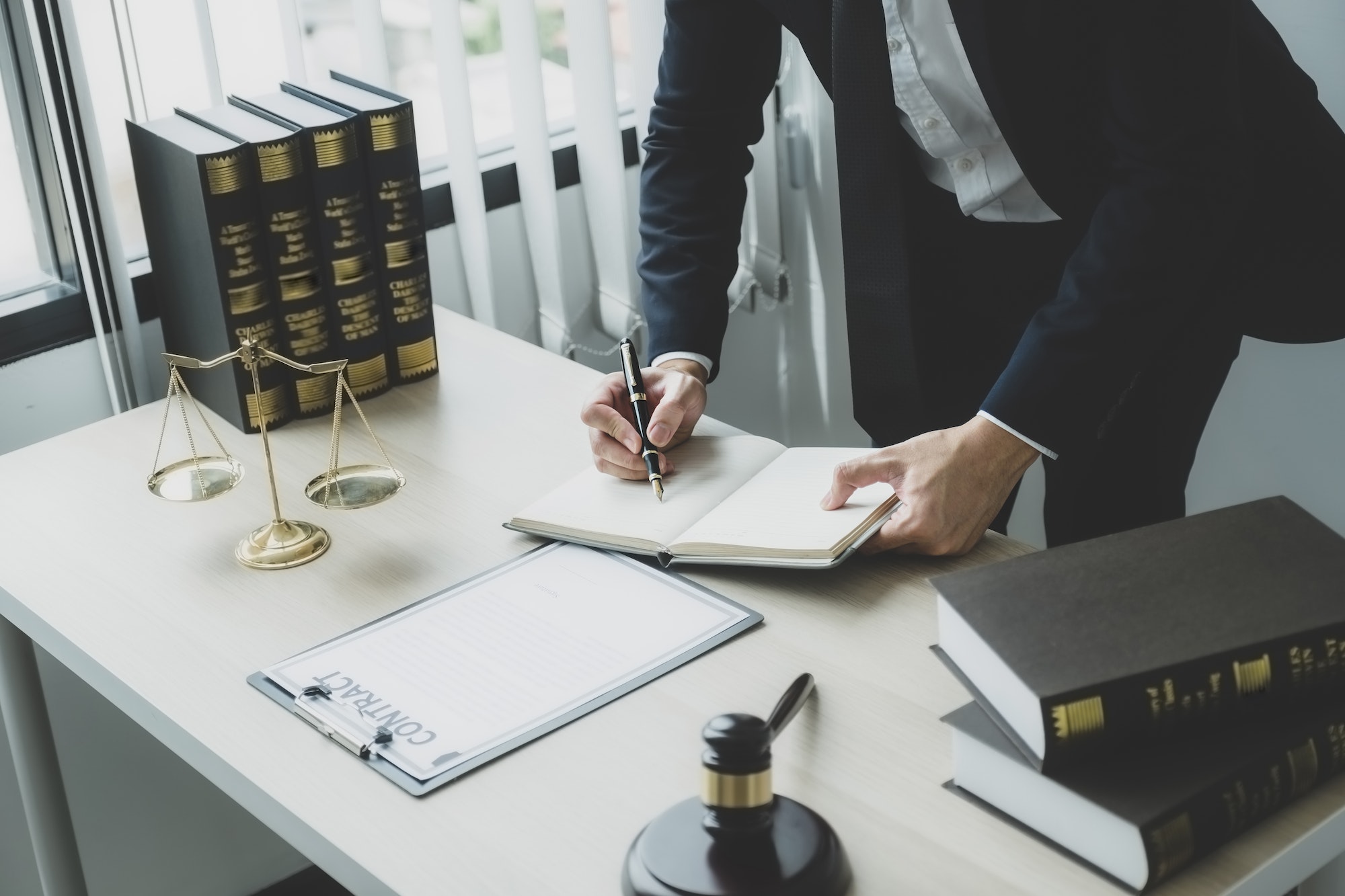 Lawyer hand holding pen and providing legal consult business dispute service at the office